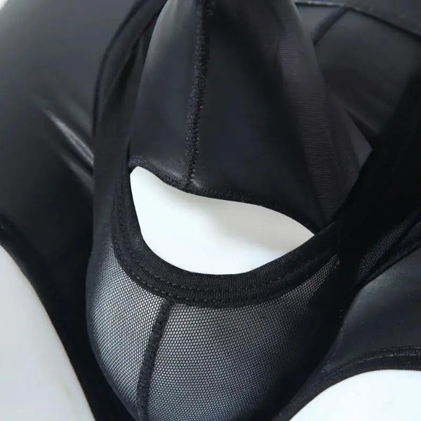 Close-up of black leather-look boxers with a sheer mesh panel and curved cutout