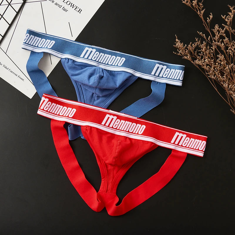 Two Menmono jockstraps in blue and red with contrasting logo waistbands, arranged on a black surface