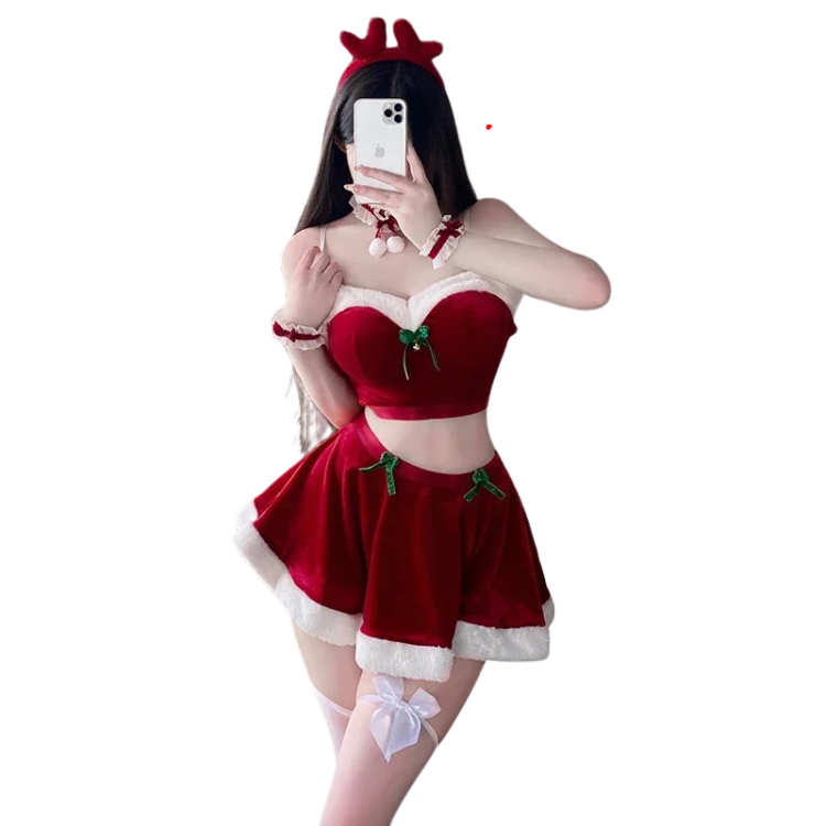 Front-facing model taking a mirror selfie in a red Santa crop-top costume and skirt