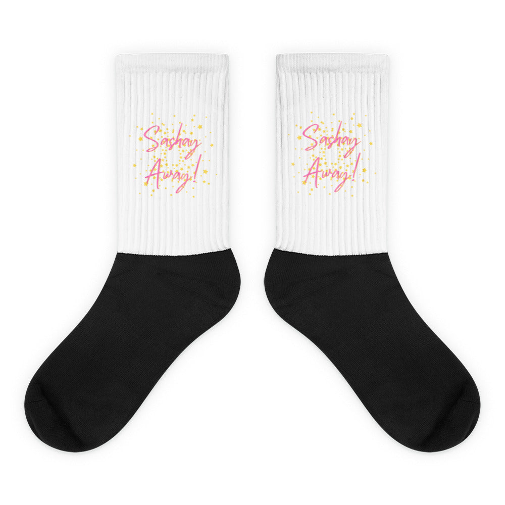 Pair of black-and-white socks with pink “Sashay Away!” lettering and yellow stars