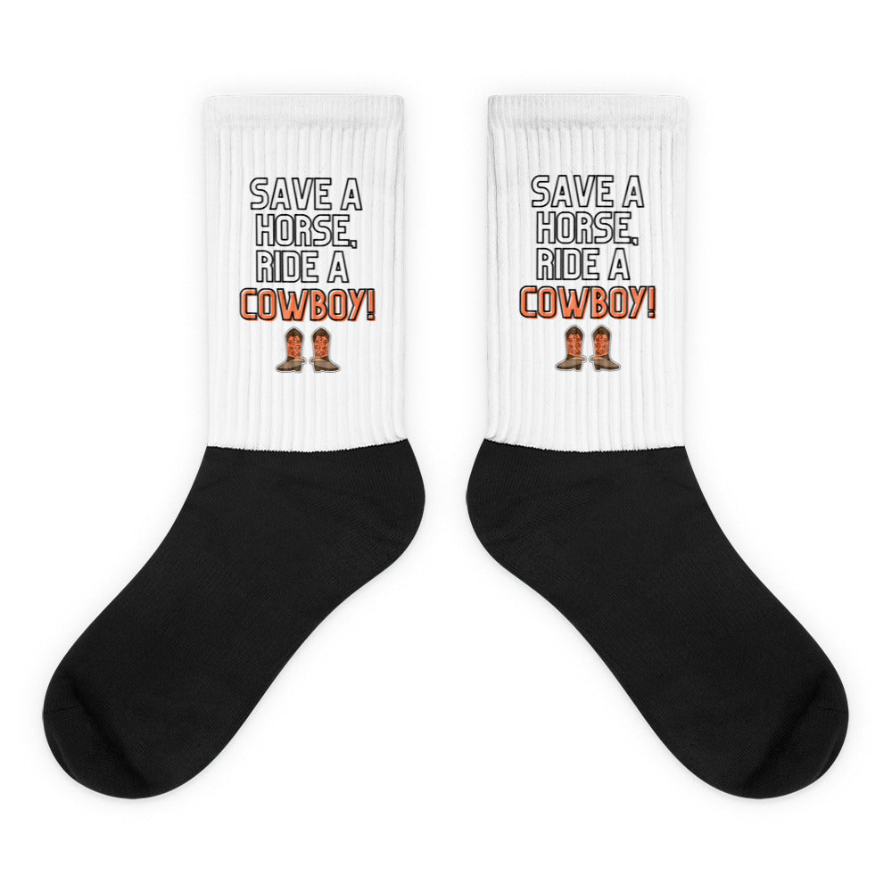Pair of black-and-white socks reading “SAVE A HORSE, RIDE A COWBOY!” with boot graphics