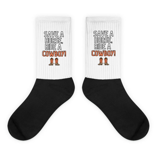 Pair of black-and-white socks reading “SAVE A HORSE, RIDE A COWBOY!” with boot graphics