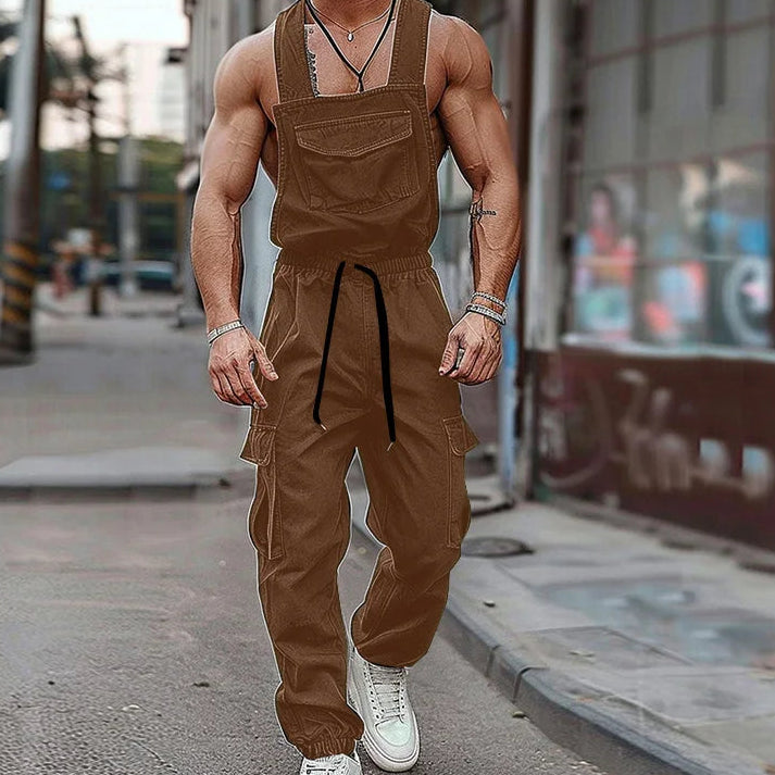 Brown cargo overalls with bib pocket, drawstring waist and multiple utility pockets, worn on a city street