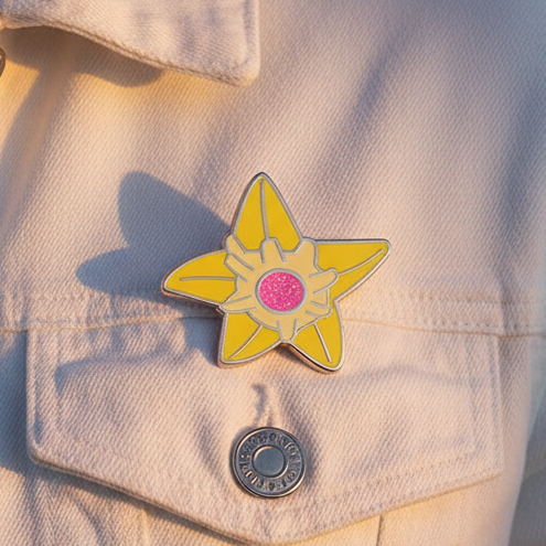 Yellow five-point star enamel pin with a pink center on a beige jacket pocket