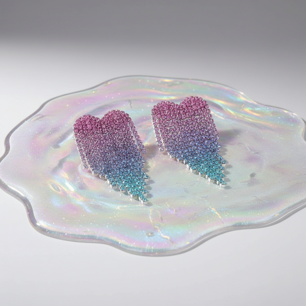 Pink and blue rhinestone heart earrings on an iridescent dish