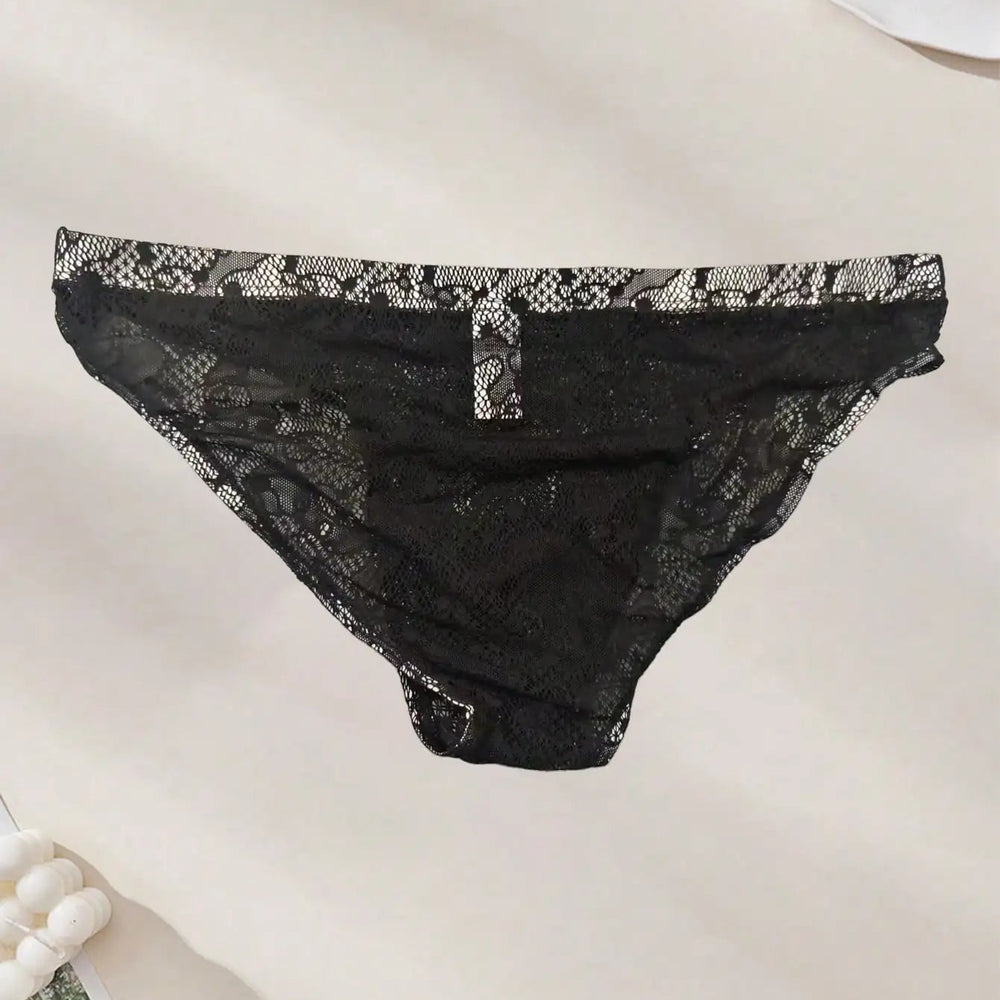 Front view of black floral lace briefs laid flat on a light surface