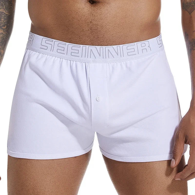 Front close-up of a model wearing white cotton boxers with a button fly and logo waistband