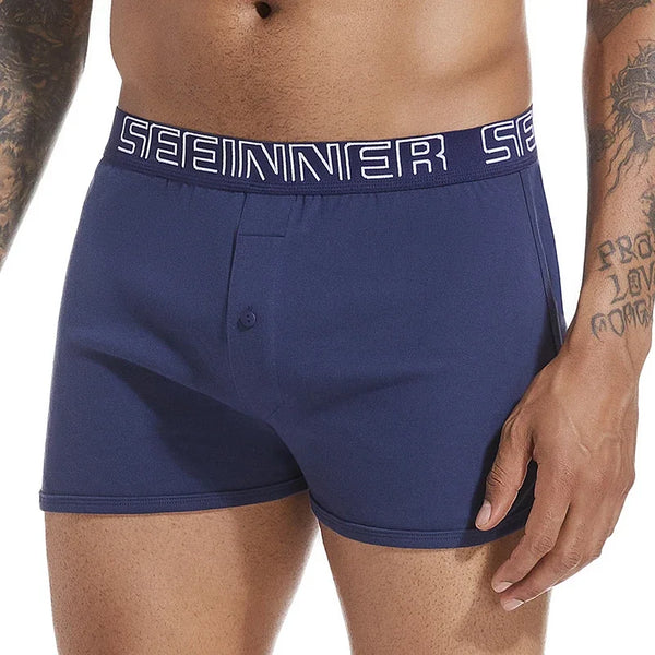 Front close-up of a model wearing navy cotton boxers with a button fly and branded waistband