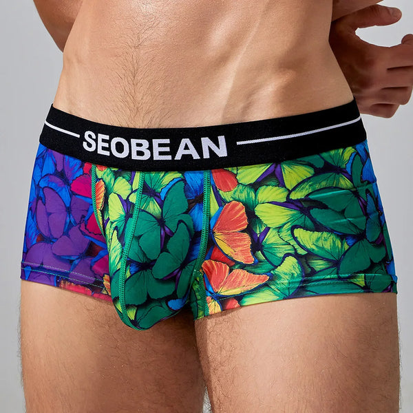 Front view of a model wearing colorful butterfly-print boxer briefs with a SEOBEAN waistband