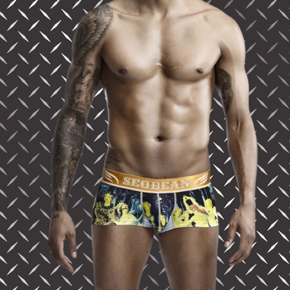 Front view of a tattooed model wearing low-rise graphic boxer briefs with a gold SEOBEAN waistband