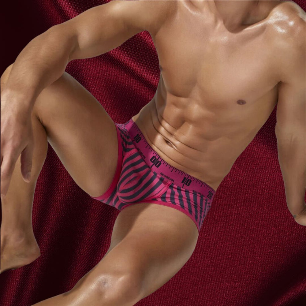 Cropped model wearing pink-and-black striped boxer briefs with a marked waistband