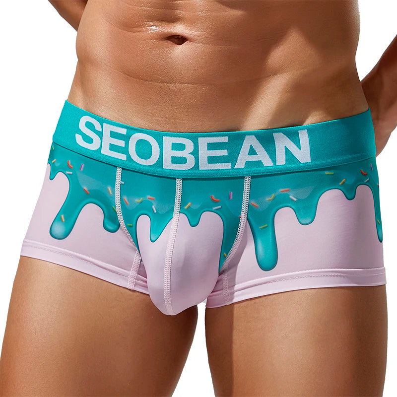 Front view of a model wearing pink boxer briefs with turquoise melting-drip print and SEOBEAN waistband
