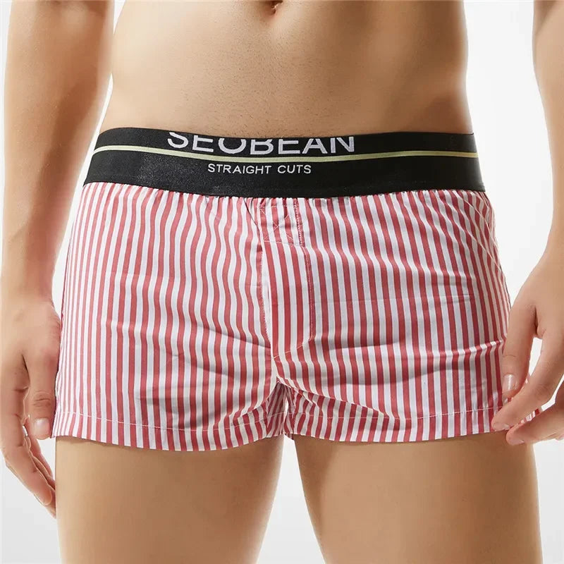 Front view of a model wearing red-and-white vertically striped boxer shorts