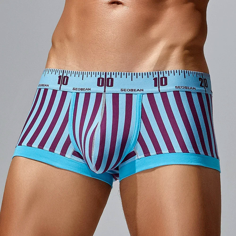 Front view of a model wearing turquoise and burgundy striped boxer briefs with a numbered ruler waistband