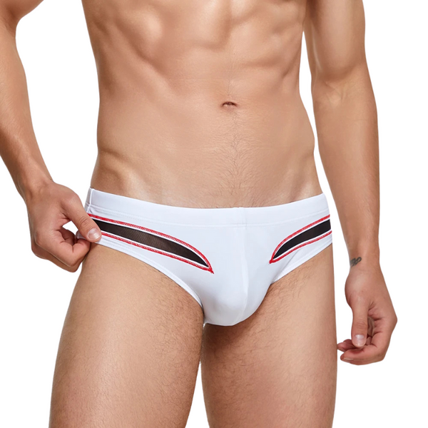 Front view of a model wearing white men's swim briefs with red and black curved trim