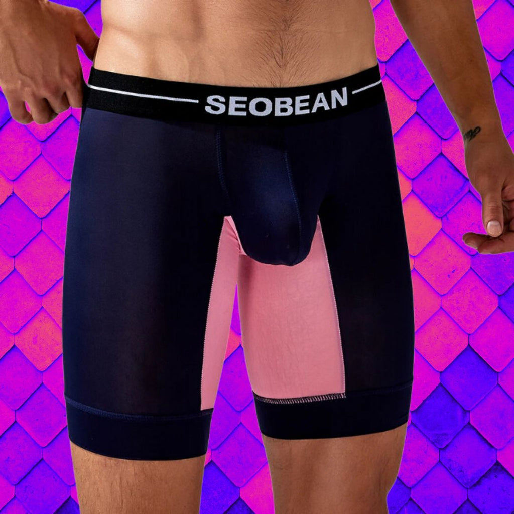 Front close-up of a model wearing black long boxers with pink leg panels and a SEOBEAN waistband