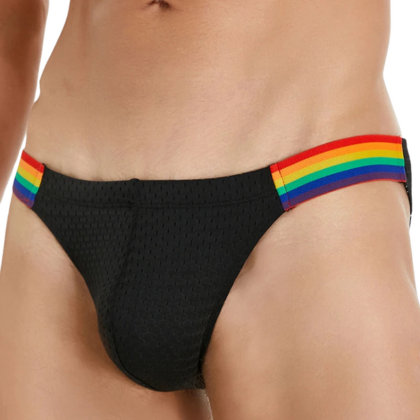 Front close-up of a model wearing black low-rise briefs with rainbow-striped sides