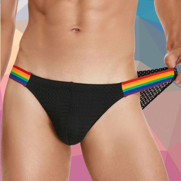 Front close-up of a model wearing black mesh low-rise briefs with rainbow-striped side bands