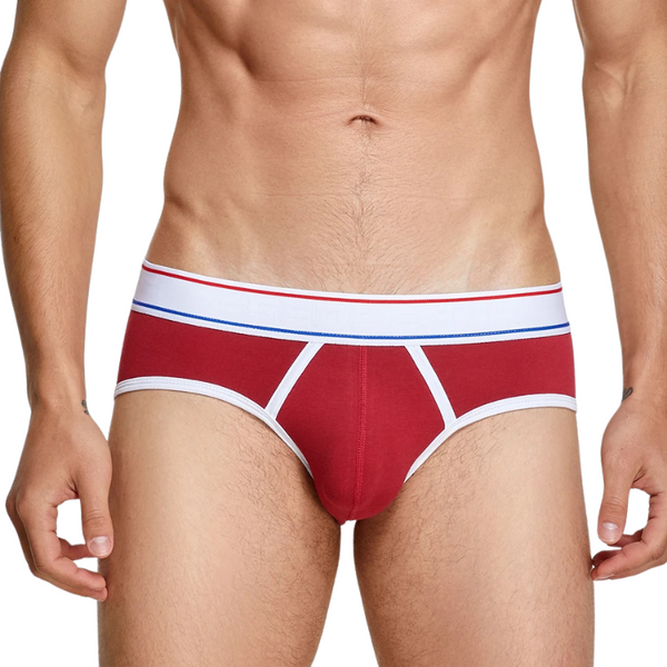 Front view of a model wearing red men's briefs with white trim and striped waistband