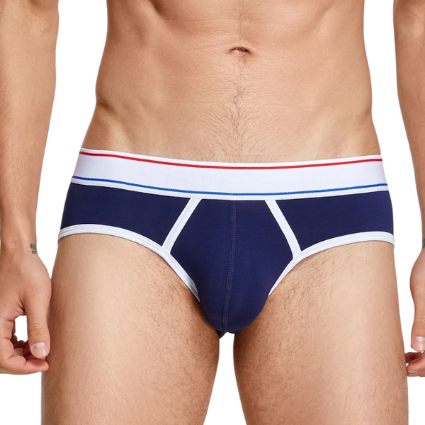 Front close-up of a model wearing navy men's briefs with white trim and red-blue waistband stripes