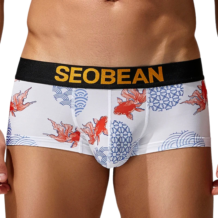 Front view of a model wearing white briefs with red fish and blue wave patterns