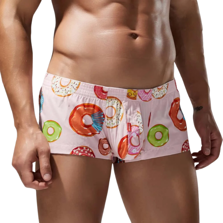 Front view of a model wearing pink cotton boxers with colorful donut prints