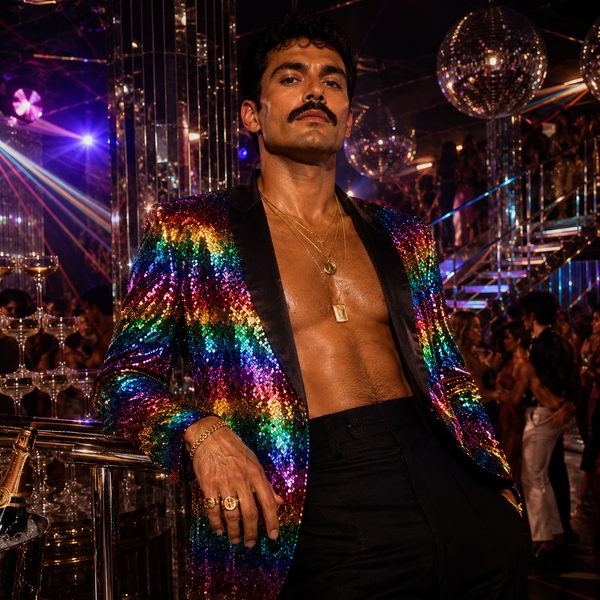 Person wearing an open rainbow sequin blazer with black satin lapels at a disco party