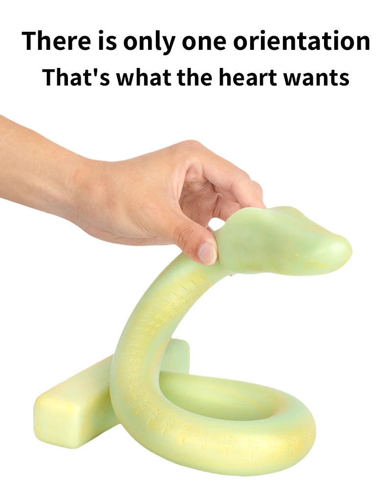 Hand holding a pale green curved snake-shaped dildo with a looped base