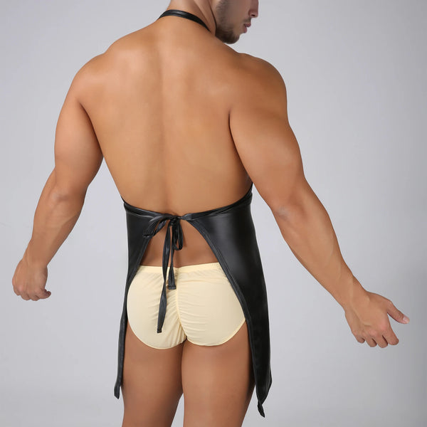 Rear view of a shirtless model wearing a black faux-leather apron harness over cream briefs