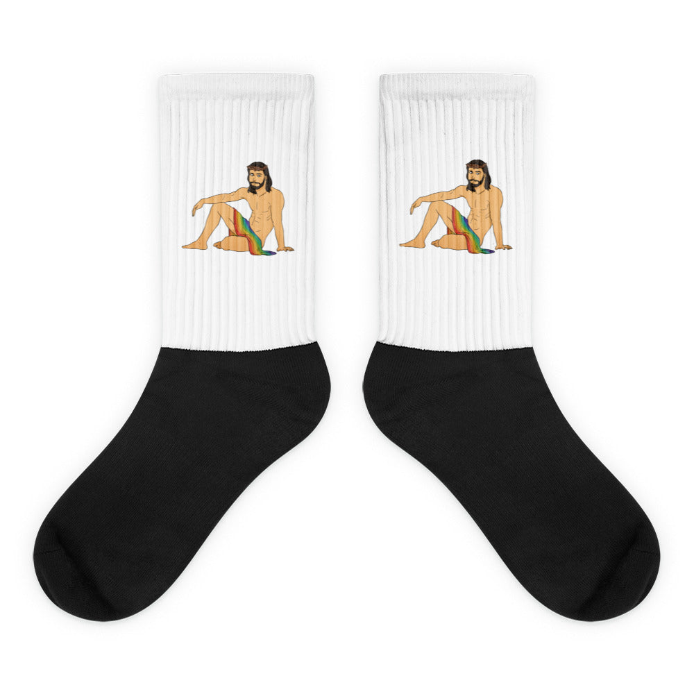 Pair of white-and-black socks featuring seated bearded Jesus with a rainbow cloth