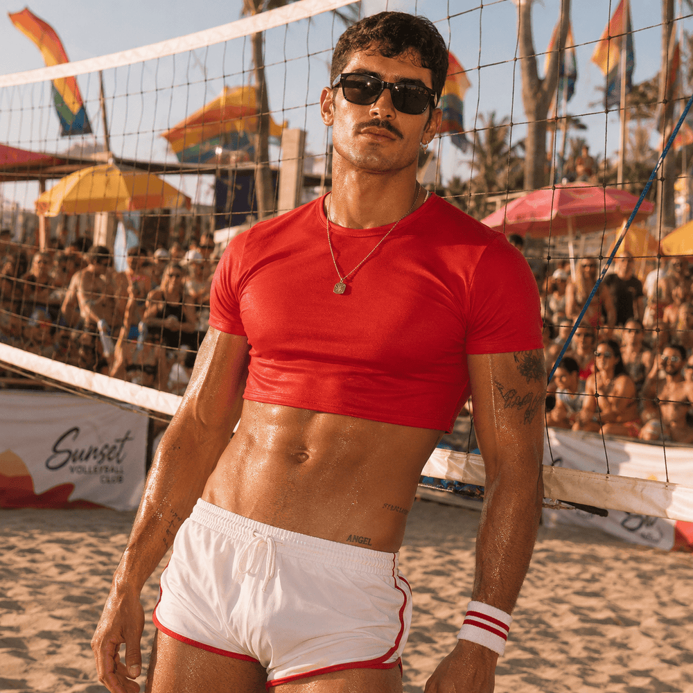 Model wearing a fitted red short-sleeve crop top at a beach volleyball court