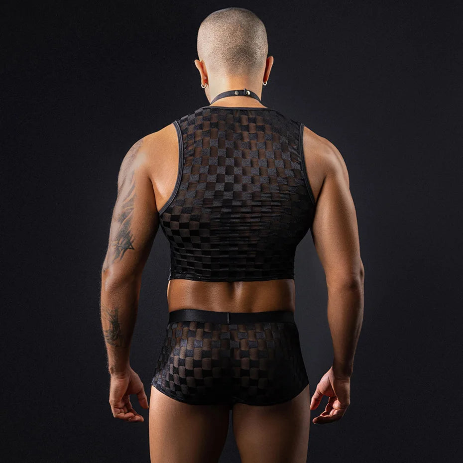 Rear view of a bald, tattooed man modeling a black checkered crop top and shorts