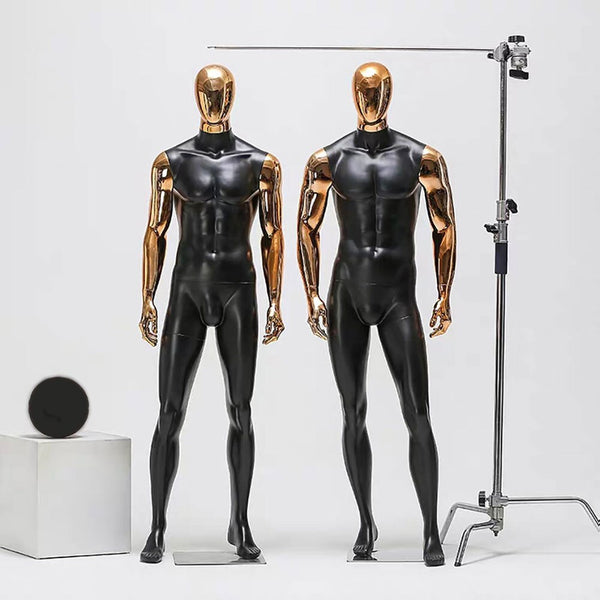 Two headless male mannequins model glossy black full-body spandex suits in a studio
