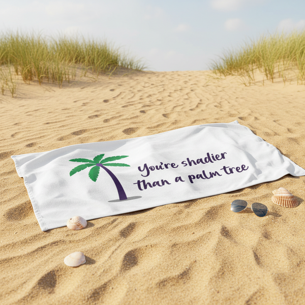 Beach towel with green and purple palm tree art and “Youre shadier than a palm tree” text