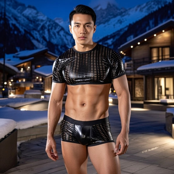 Front-facing model in a black leather-look mesh crop top and matching shorts outdoors at night