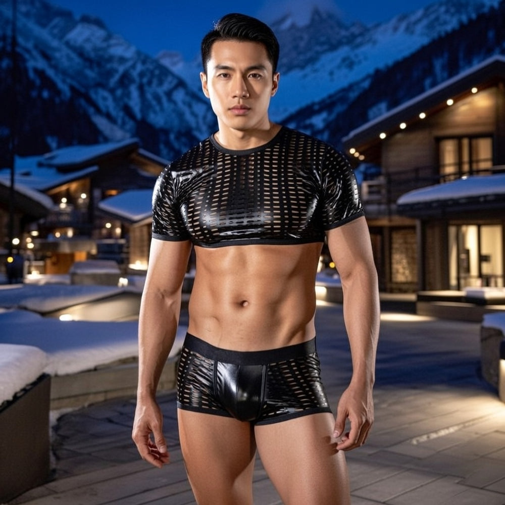 Front-facing model in a black leather-look mesh crop top and matching shorts outdoors at night