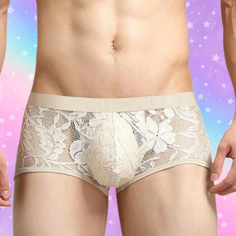 Front view of a model wearing beige floral lace briefs with a wide waistband