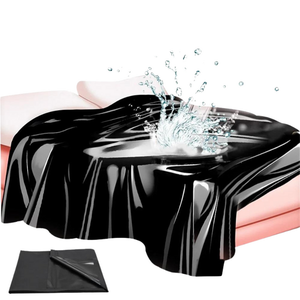 Glossy black waterproof sheet draped over a pink bed with water splashing on it