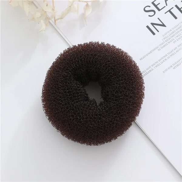 Brown mesh donut-shaped bun maker photographed from above on a white background