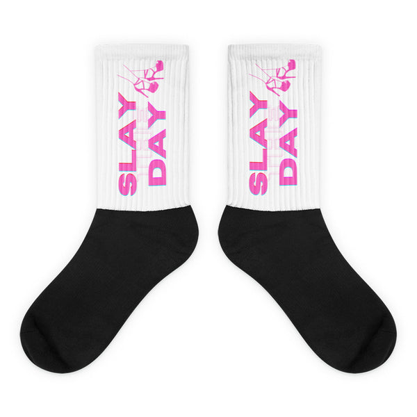 Pair of black-and-white socks with pink “SLAY DAY” lettering and dancing figure