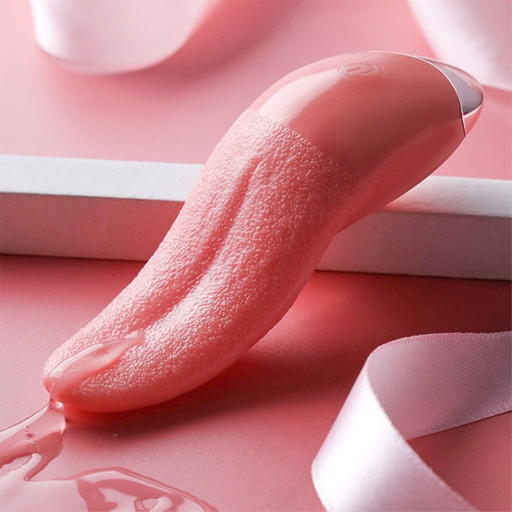 Pink tongue-shaped vibrator with textured surface, resting on a pink-and-white set