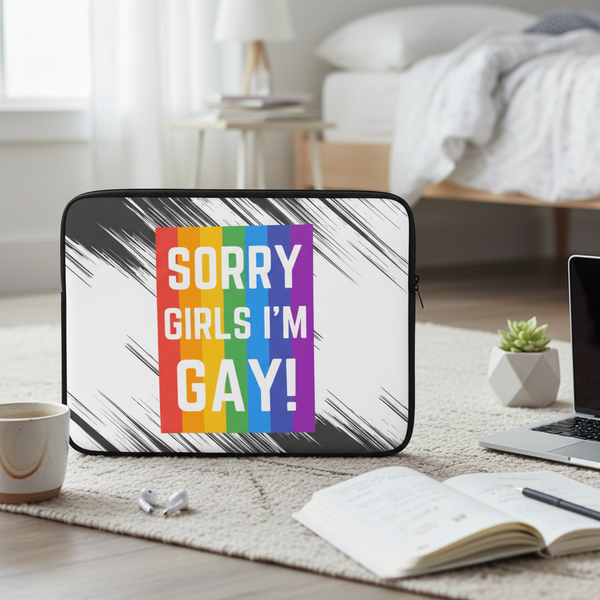 I'm Gay! laptop sleeve in bold white letters on rainbow stripes, upright on carpet by coffee, notebook