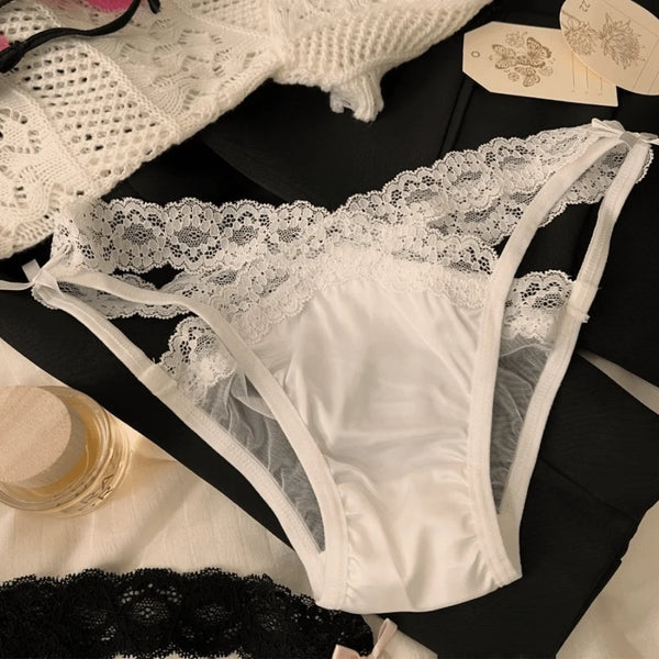 Flat lay of white lace briefs with sheer mesh panels and side ties