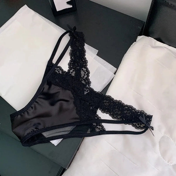Flat lay of black lace briefs with satin front panels and small bow details