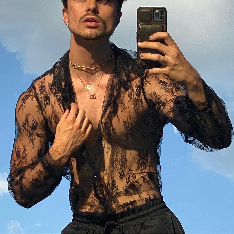 Person taking a mirror selfie in a sheer black floral lace button-up shirt