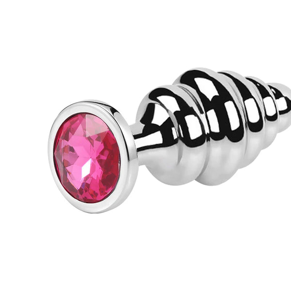 Close-up of a stainless steel ribbed butt plug with a large faceted pink jewel