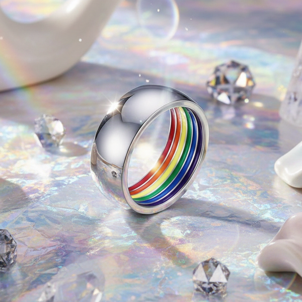 Silver ring with a rainbow-striped inner band displayed on an iridescent surface
