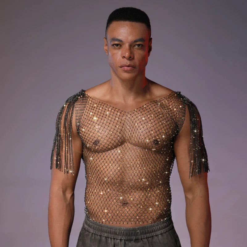 Front-facing model wearing a sheer, rhinestone-studded mesh tank with shoulder fringe