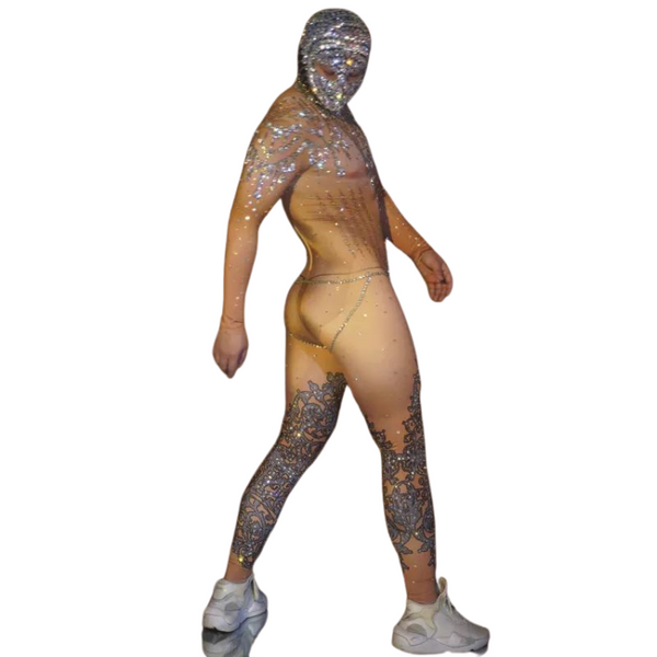 Rear three-quarter view of a person in a sheer jeweled bodysuit with ornate leg panels and sneakers