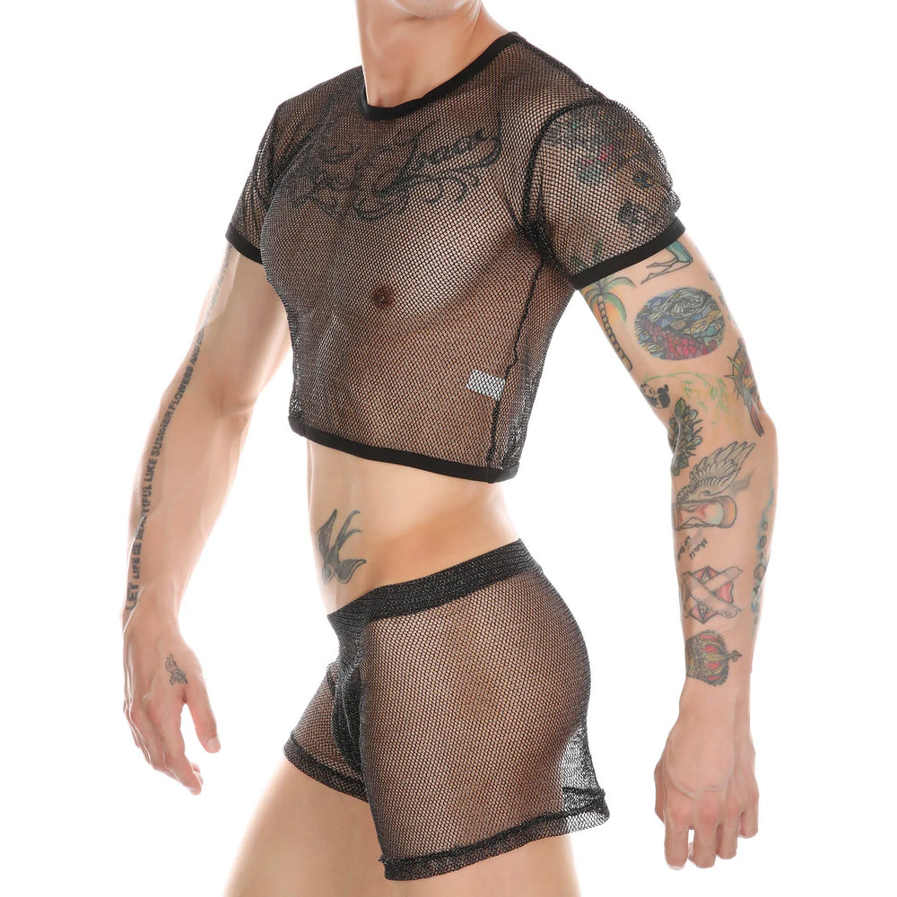 Cropped front view of a tattooed model wearing a black mesh crop top and matching boxers